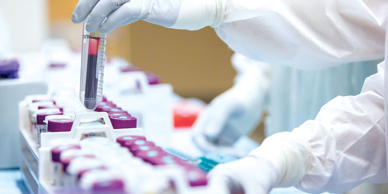 Scientists work with vials of blood samples